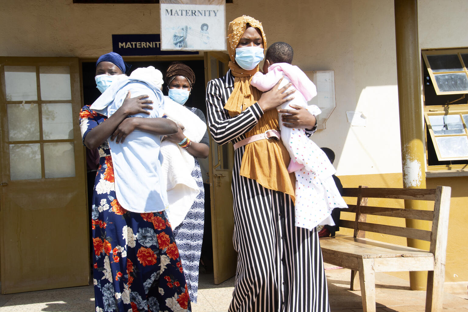 Young mothers carrying their babies at a health clinic in Uganda.