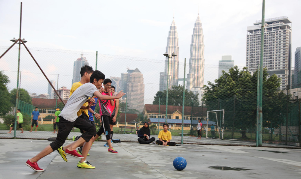 adolescents playing soccer in a urban playground