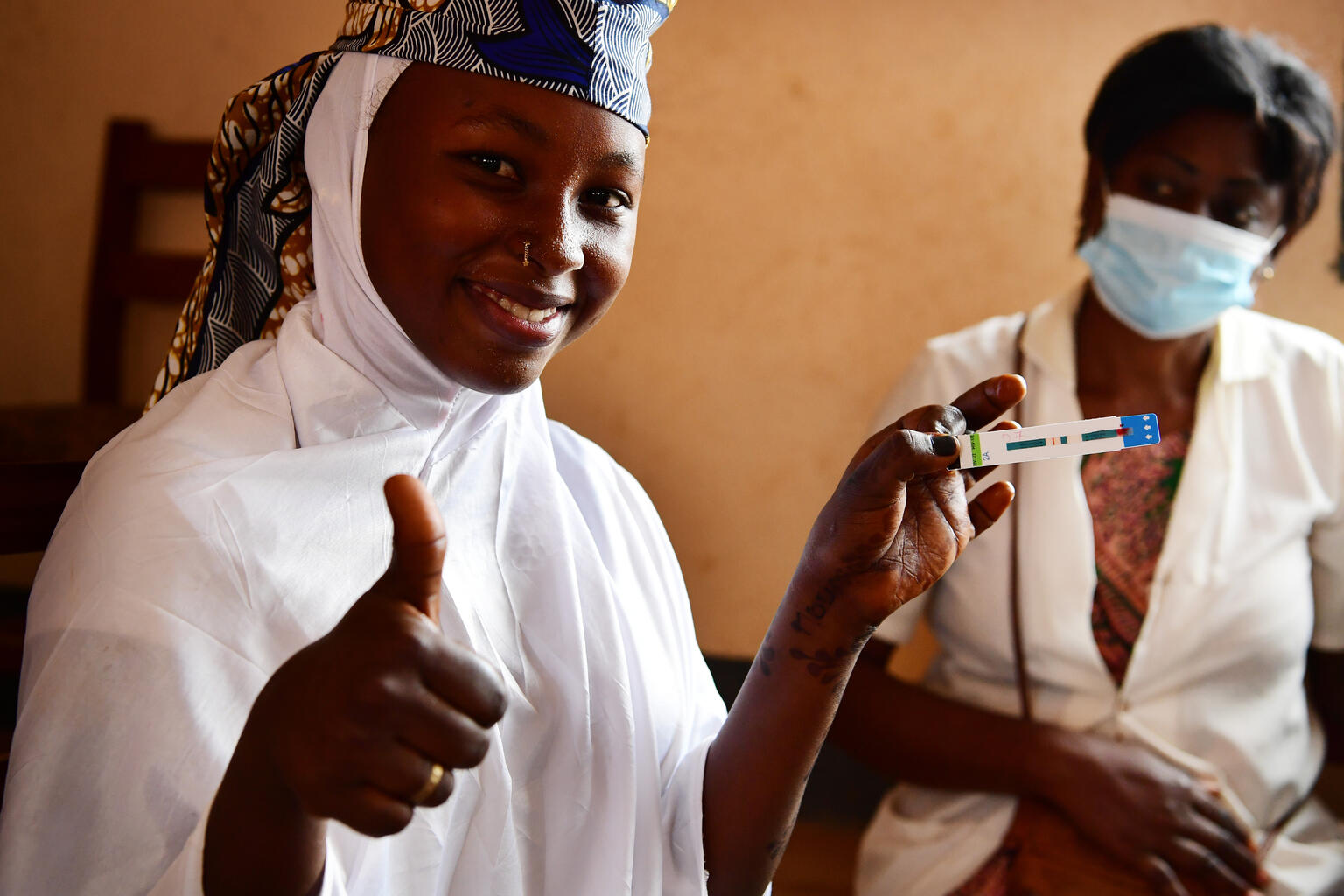 An adolescent girl poses with a test strip in Cameroon