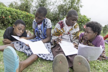 Four adolescent girls studying outside