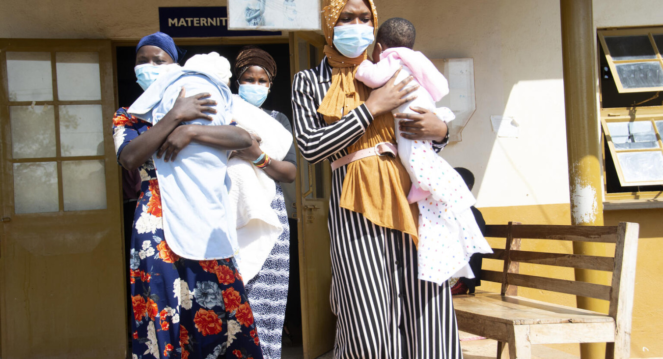 Young mothers carrying their babies at a health clinic in Uganda.
