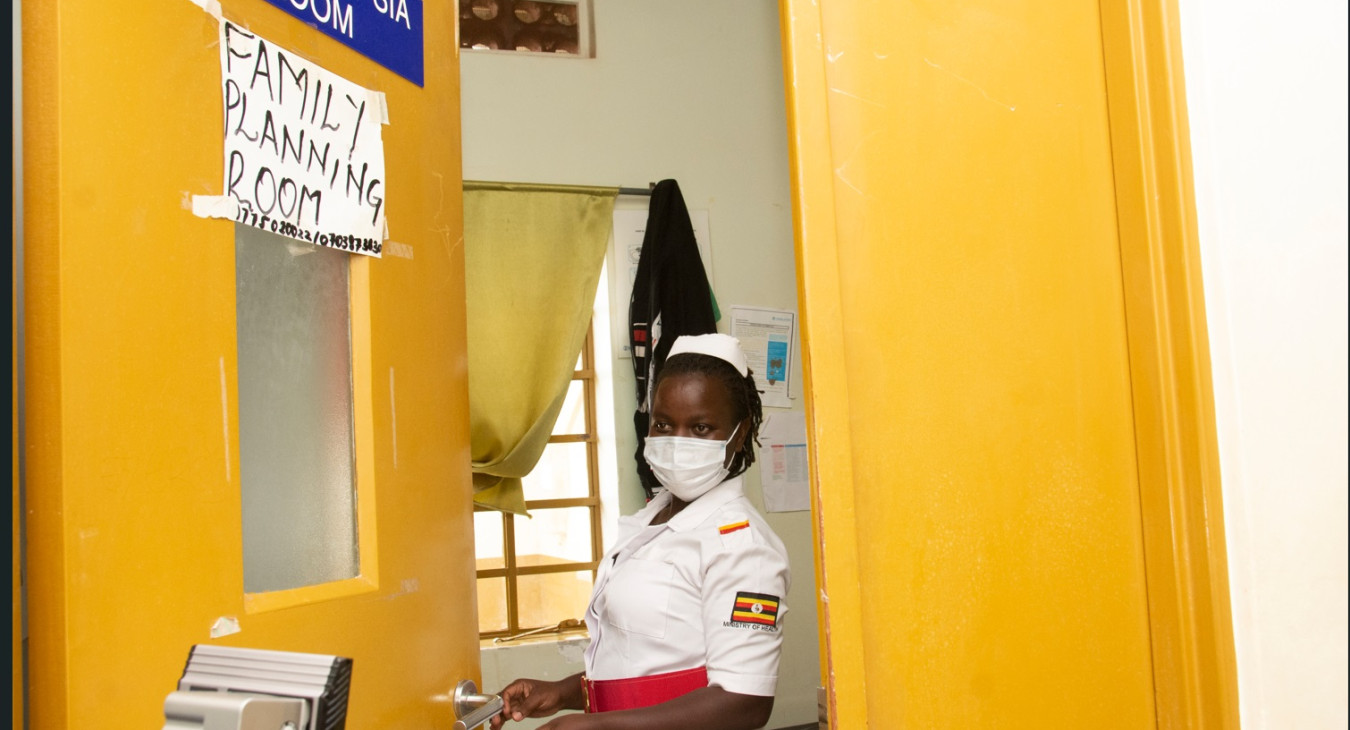 A registered midwife waits for a client to enter the family planning room at Buyinja Health Centre IV in Namayingo District, Uganda.